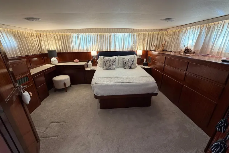 Lady Rae Yacht Photos Pics Luxurious bedroom interior of 1987 Hatteras 58 Motor Yacht with elegant wood furnishings.