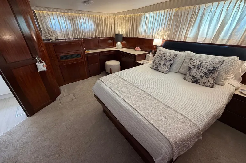 Lady Rae Yacht Photos Pics Luxurious bedroom interior of 1987 Hatteras 58 Motor Yacht with elegant decor and cozy bedding.