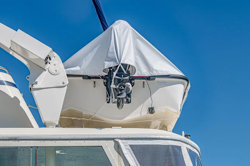 Lady Rae Yacht Photos Pics 1987 Hatteras 58 Motor Yacht with covered dinghy on deck against blue sky.