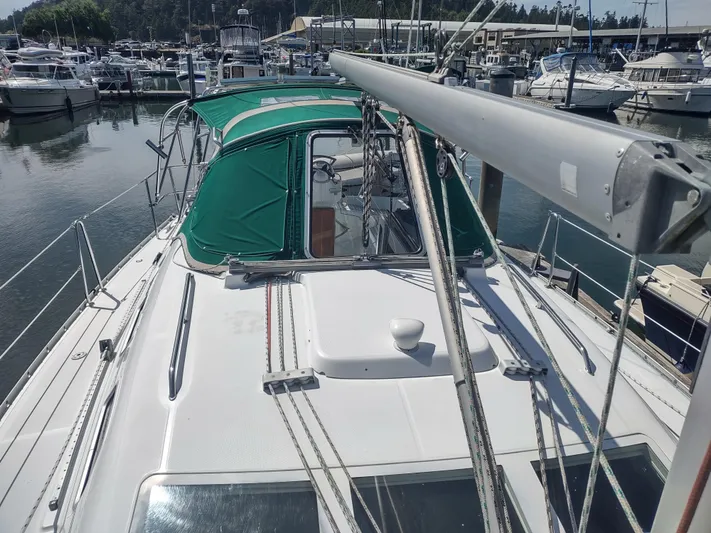 Rarebird Yacht Photos Pics 2004 Beneteau 393 sailboat docked at a marina, featuring green canopy and rigging.