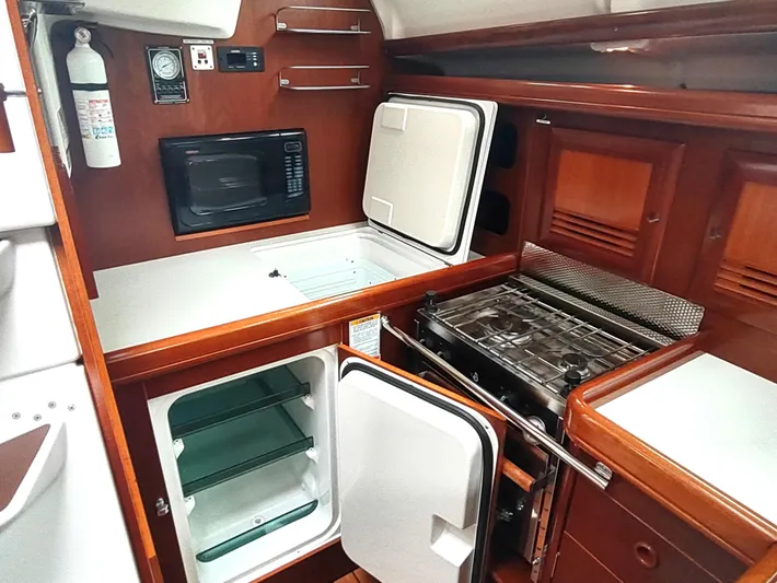 Rarebird Yacht Photos Pics 2004 Beneteau 393 yacht kitchen with stove, fridge, and microwave.