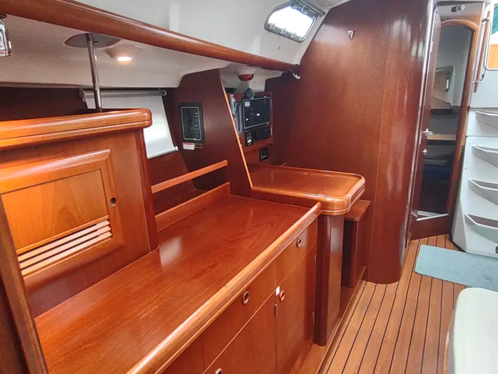 Rarebird Yacht Photos Pics Interior of 2004 Beneteau 393 sailboat with polished wood cabinetry and flooring.