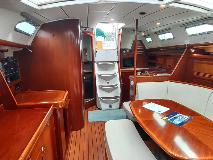 Rarebird Yacht Photos Pics Interior of 2004 Beneteau 393 yacht with wood finish and cozy seating area.