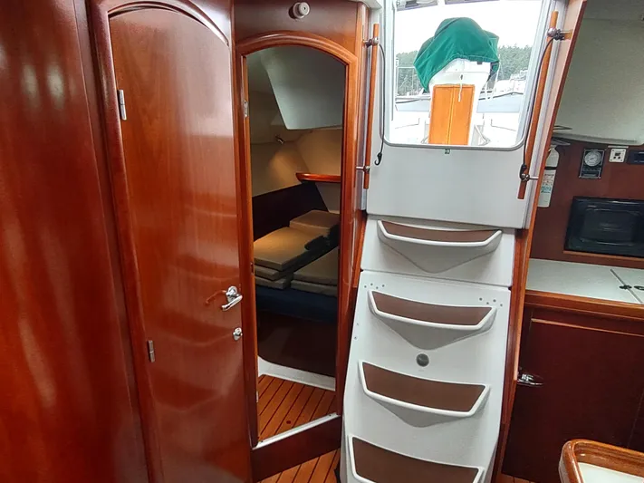 Rarebird Yacht Photos Pics Interior of 2004 Beneteau 393 sailboat, featuring wooden cabinetry and cabin access.