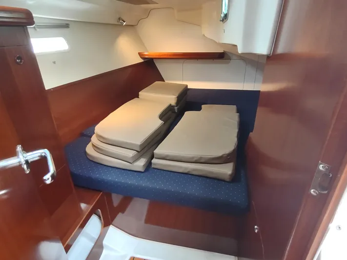 Rarebird Yacht Photos Pics 2004 Beneteau 393 cabin interior with stacked cushions and wooden finish.