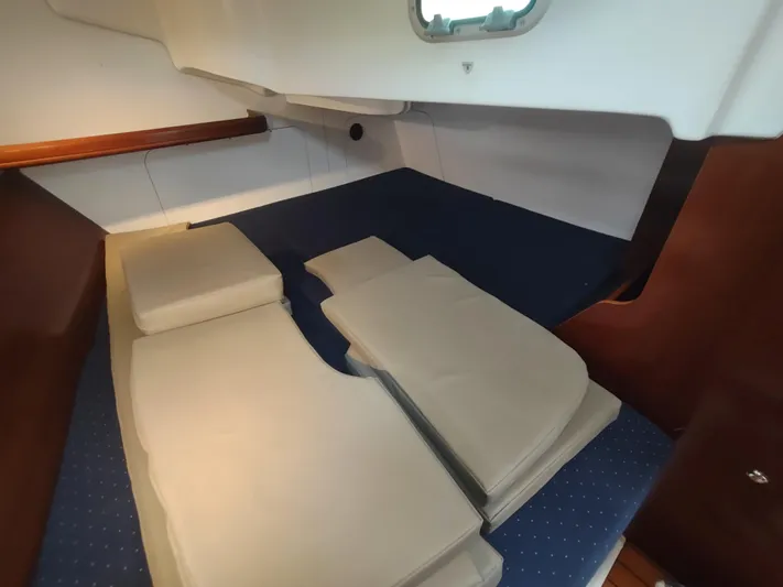 Rarebird Yacht Photos Pics Interior cabin of 2004 Beneteau 393 sailboat with cushions and wooden accents.