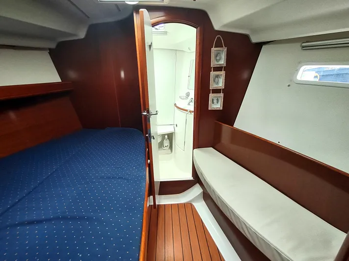 Rarebird Yacht Photos Pics Interior of a 2004 Beneteau 393 yacht cabin with bed and seating area.