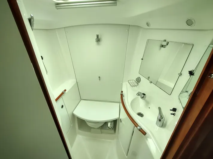 Rarebird Yacht Photos Pics 2004 Beneteau 393 yacht bathroom with sink, mirror, and toilet.