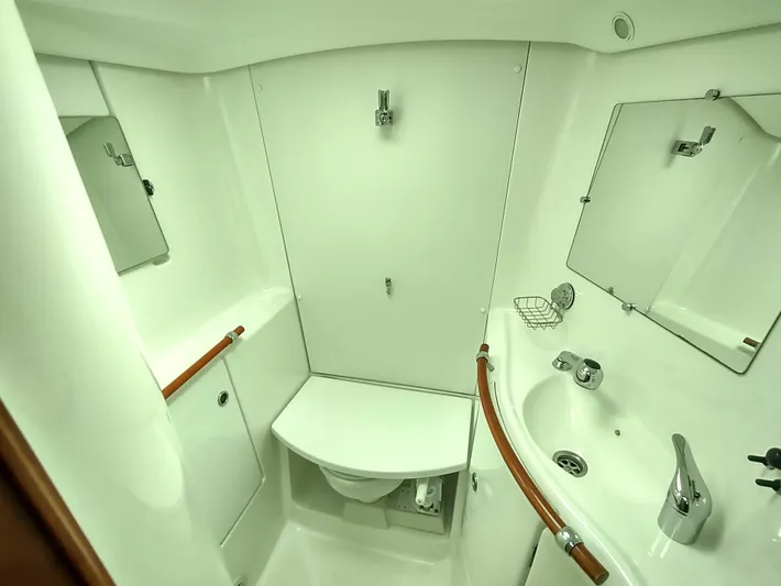 Rarebird Yacht Photos Pics 2004 Beneteau 393 yacht bathroom with sink, mirror, and toilet.