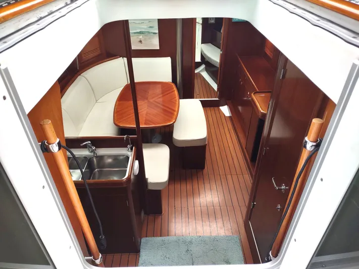 Rarebird Yacht Photos Pics Interior of 2004 Beneteau 393 yacht with wooden flooring and cozy seating area.