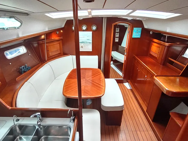 Rarebird Yacht Photos Pics Interior of 2004 Beneteau 393 sailboat with wood finish and cozy seating area.