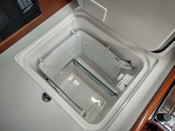 Rarebird Yacht Photos Pics Open storage compartment on a 2004 Beneteau 393 yacht, featuring a white interior.