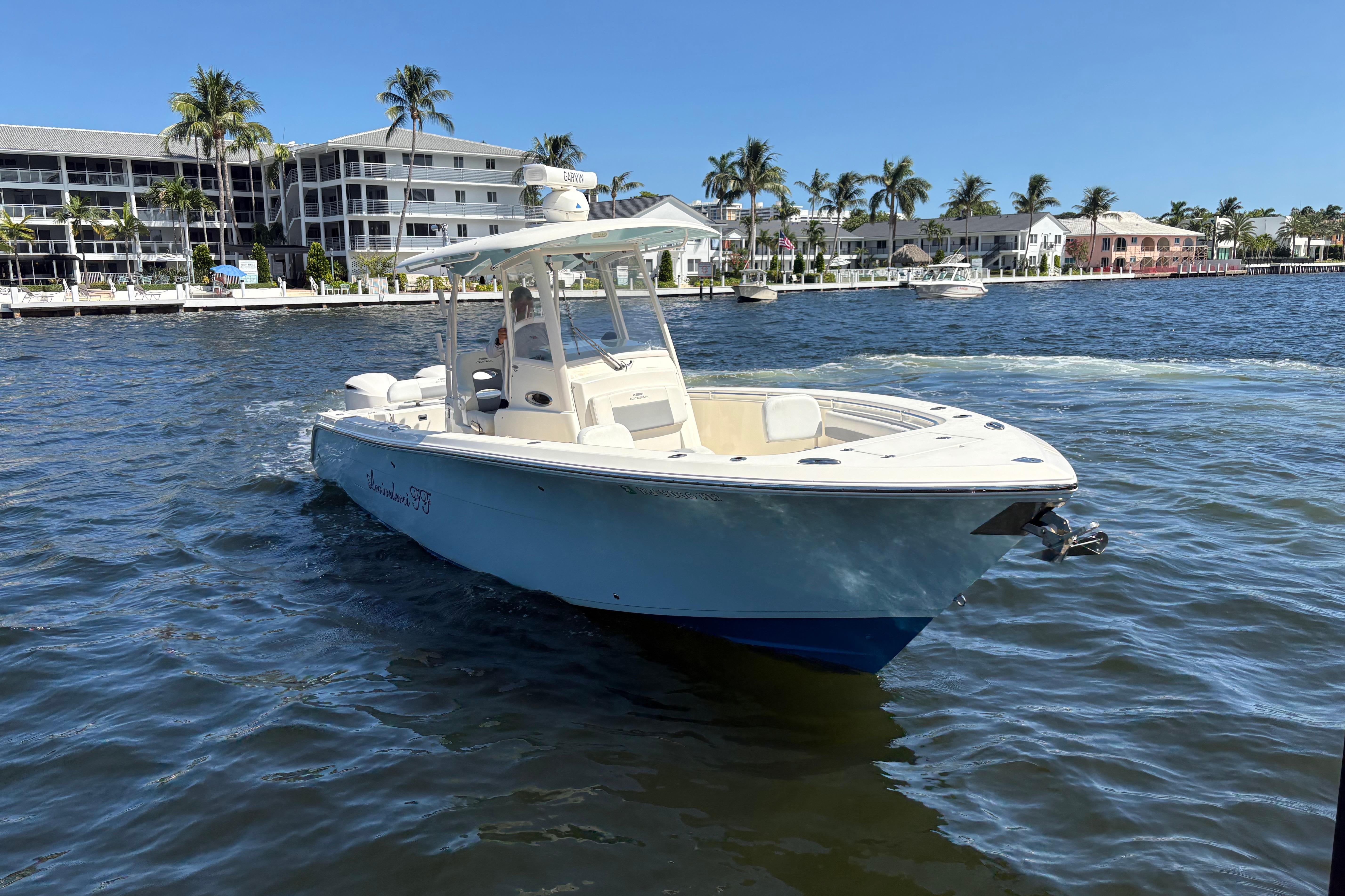 2018 Cobia 301 Center Console boat on water near waterfront homes.