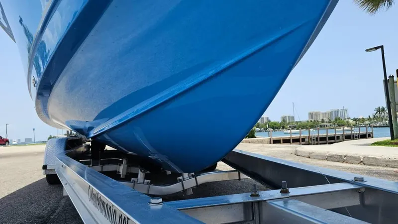  Yacht Photos Pics 2023 Sea Hunt Ultra 305 SE boat on trailer, blue hull, waterfront background.