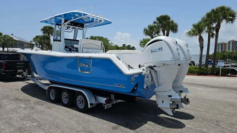  Yacht Photos Pics 2023 Sea Hunt Ultra 305 SE boat with dual engines on a trailer, parked outdoors.