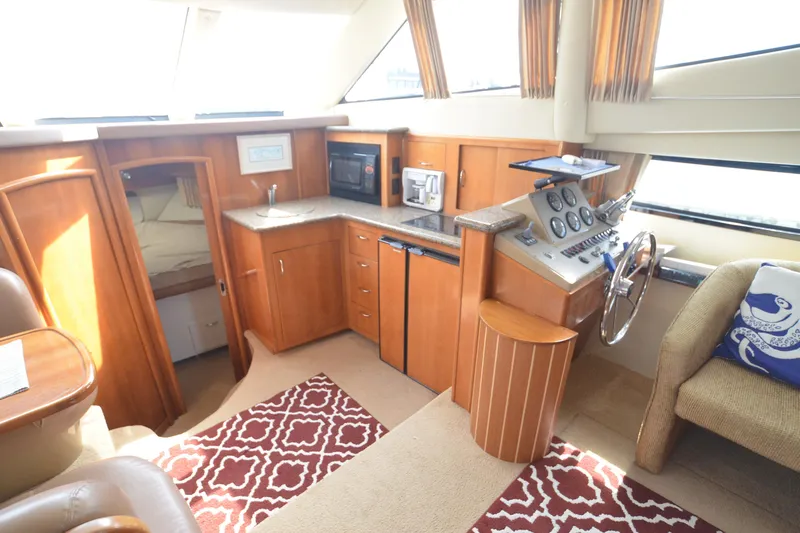 The Loon Yacht Photos Pics 2004 Carver 366 Motoryacht interior with helm, kitchenette, and cozy seating area.