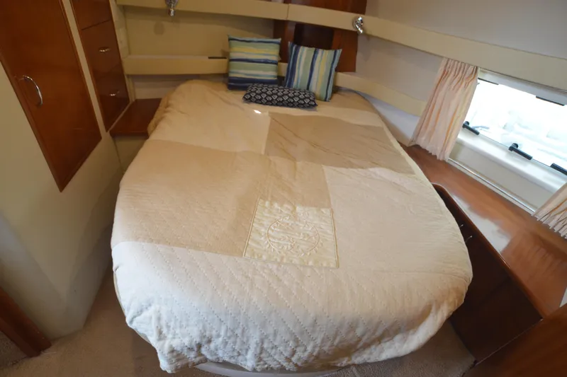 The Loon Yacht Photos Pics 2004 Carver 366 Motoryacht bedroom with cozy bed, pillows, and window view.