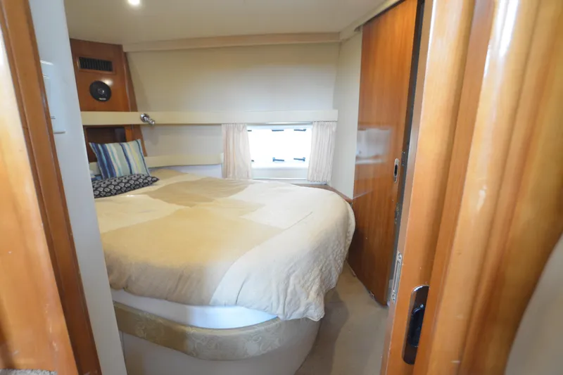 The Loon Yacht Photos Pics Cozy bedroom in 2004 Carver 366 Motoryacht with plush bedding and wooden accents.