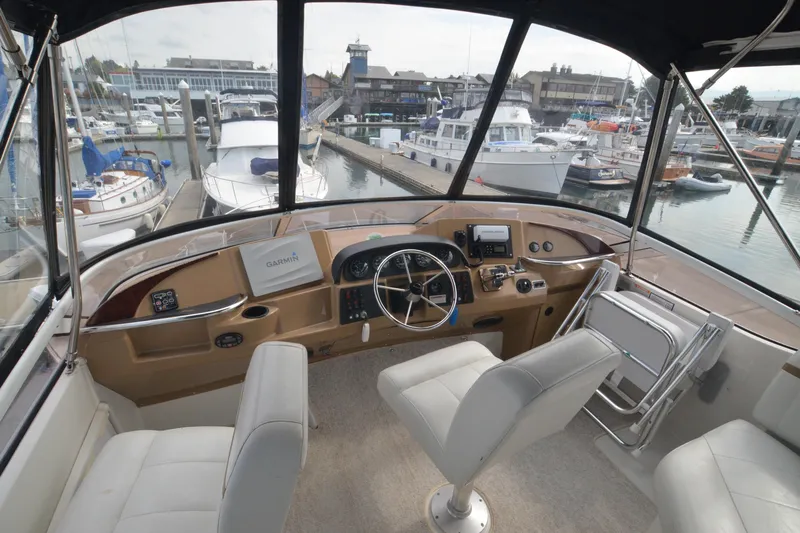The Loon Yacht Photos Pics 2004 Carver 366 Motoryacht helm with marina view, featuring modern navigation equipment.