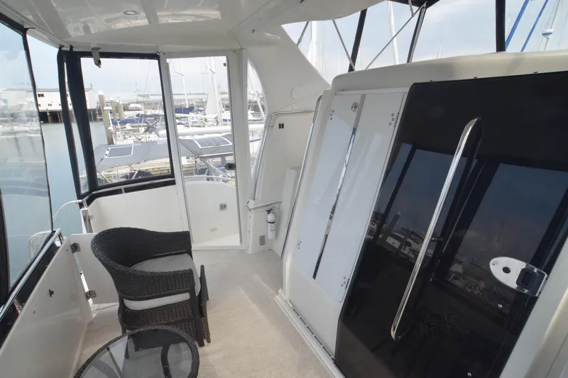 The Loon Yacht Photos Pics 2004 Carver 366 Motoryacht interior with wicker chairs and marina view.