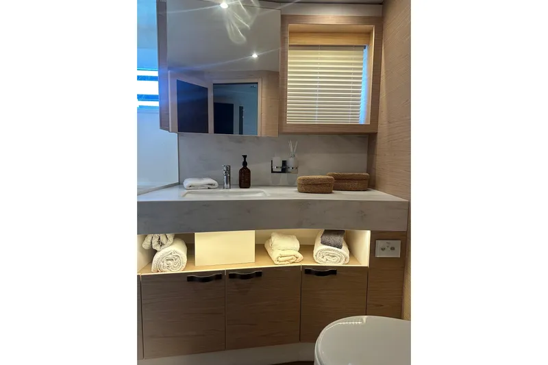Gran Firin Yacht Photos Pics Luxurious bathroom in 2024 Beneteau Grand Trawler 62, featuring modern sink and storage.