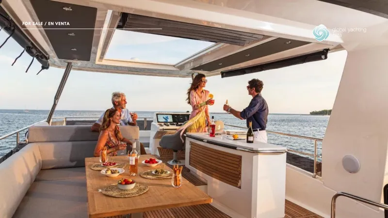 Gran Firin Yacht Photos Pics 2024 Beneteau Grand Trawler 62, people enjoying drinks on deck, ocean view.