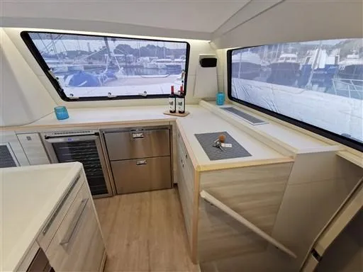  Yacht Photos Pics Modern kitchen interior of 2019 Catana 53 yacht with large windows and sleek appliances.
