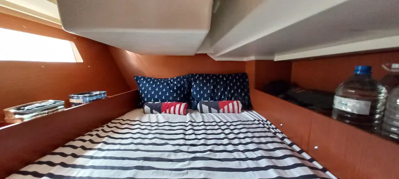 Oya Yacht Photos Pics Cozy cabin interior of 2018 Beneteau Oceanis 41.1 with striped bedding and nautical-themed pillows.