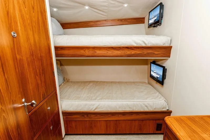 Shotgun Yacht Photos Pics Bunk beds in a 1981 Merritt 55 c yacht cabin with wood paneling and mounted screens.