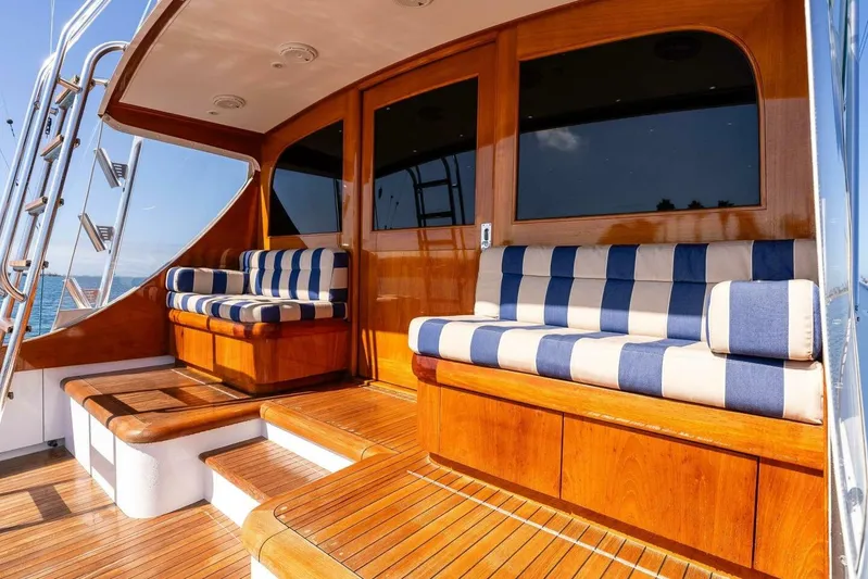 Shotgun Yacht Photos Pics Luxurious 1981 Merritt 55 c yacht deck with striped seating and wooden finishes.
