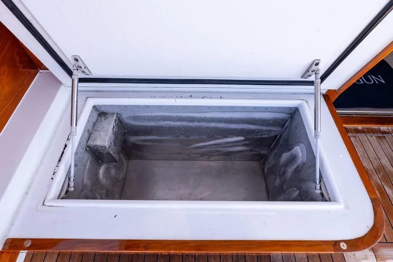 Shotgun Yacht Photos Pics Open storage compartment on 1981 Merritt 55 c boat, featuring wooden trim and metal interior.