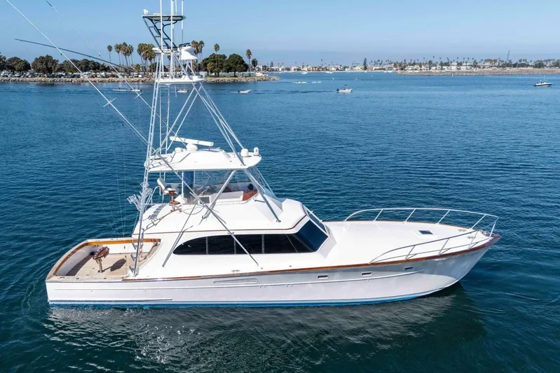 Shotgun Yacht Photos Pics 1981 Merritt 55 c yacht cruising on calm blue waters, clear sky background.