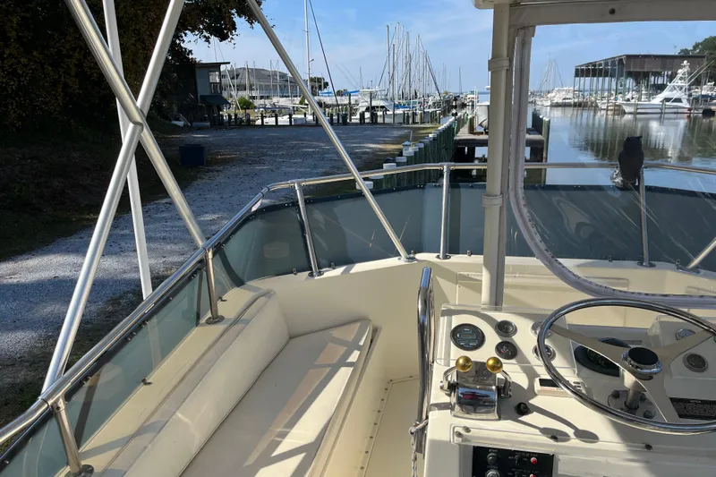 Moon Howler Yacht Photos Pics 1987 Hatteras 41 Convertible boat interior at marina, showcasing helm and seating area.
