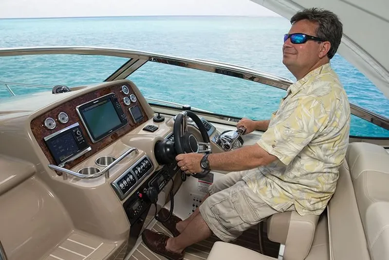 Anything For Me Too Yacht Photos Pics Man piloting a 2014 Formula 37 Cruiser yacht on open water.