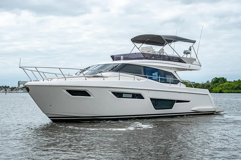 Time Chaser Yacht Photos Pics 2021 Ferretti Yachts 500 cruising on a calm river under a cloudy sky.