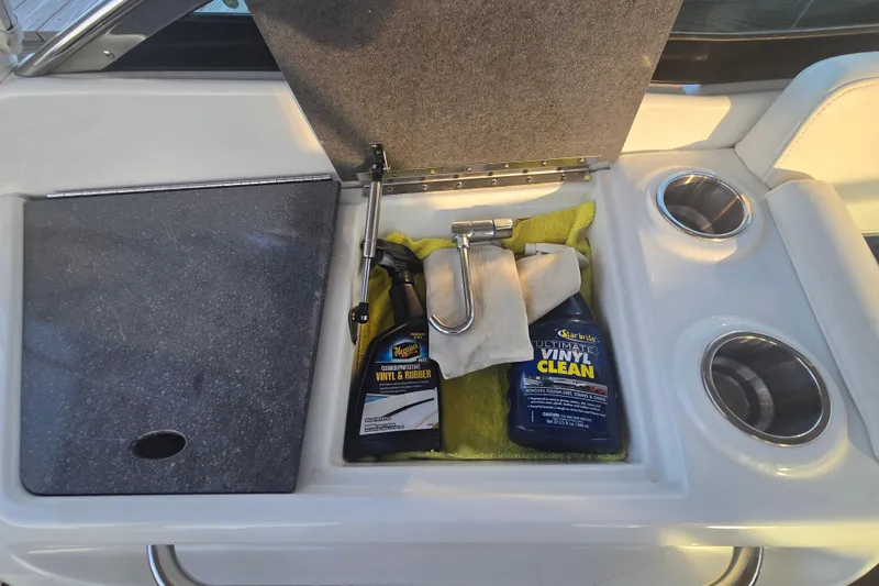 Fly Me Yacht Photos Pics Storage compartment on 2013 Formula 310 Sun Sport with cleaning supplies and cup holders.