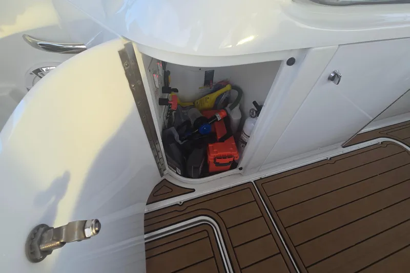 Fly Me Yacht Photos Pics Open storage compartment on 2013 Formula 310 Sun Sport boat, showing various tools and equipment.