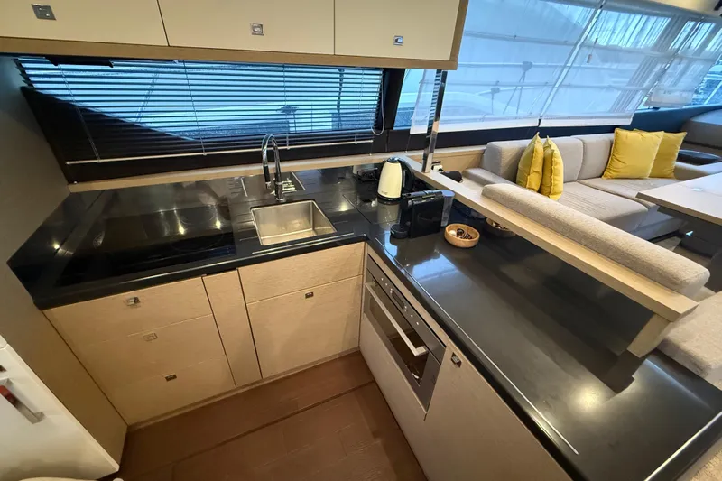  Yacht Photos Pics Modern kitchen interior on a 2016 Prestige 620S yacht, featuring sleek countertops and cozy seating.