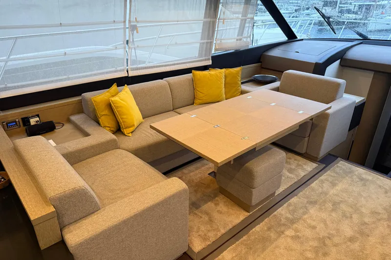  Yacht Photos Pics Luxurious interior of 2016 Prestige 620S yacht with beige seating and yellow cushions.