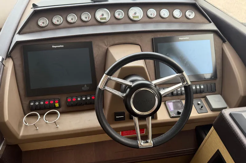  Yacht Photos Pics Cockpit of 2016 Prestige 620S yacht with dual Raymarine displays and steering wheel.