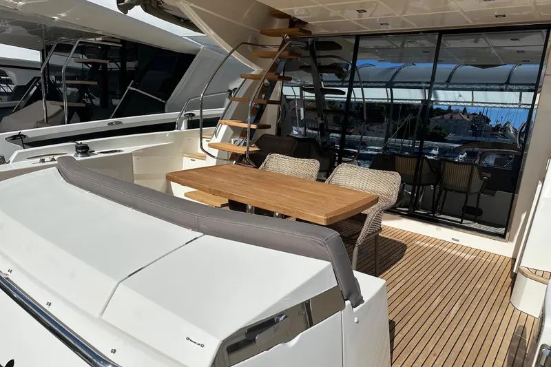  Yacht Photos Pics Outdoor seating area on 2016 Prestige 620S yacht with wooden table and wicker chairs.