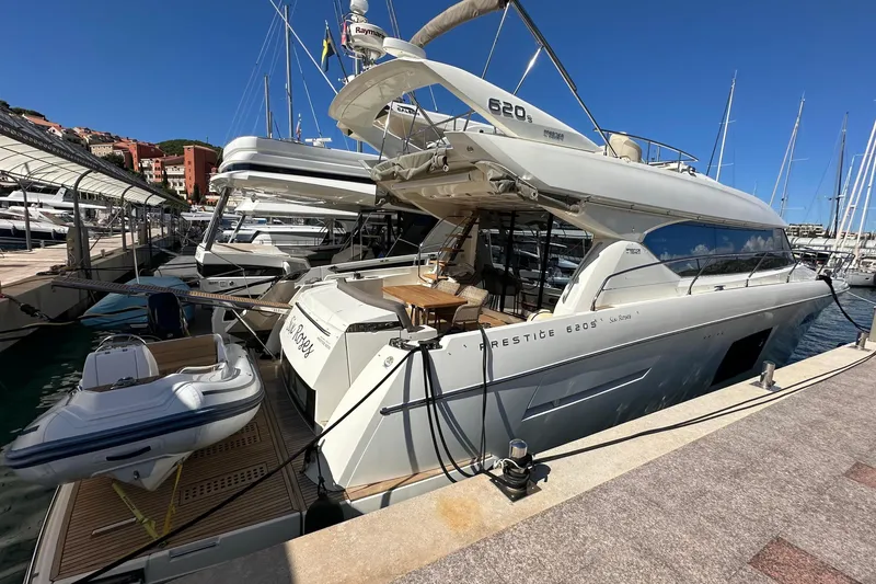  Yacht Photos Pics Luxury 2016 Prestige 620S yacht docked at marina, featuring sleek design and spacious deck.