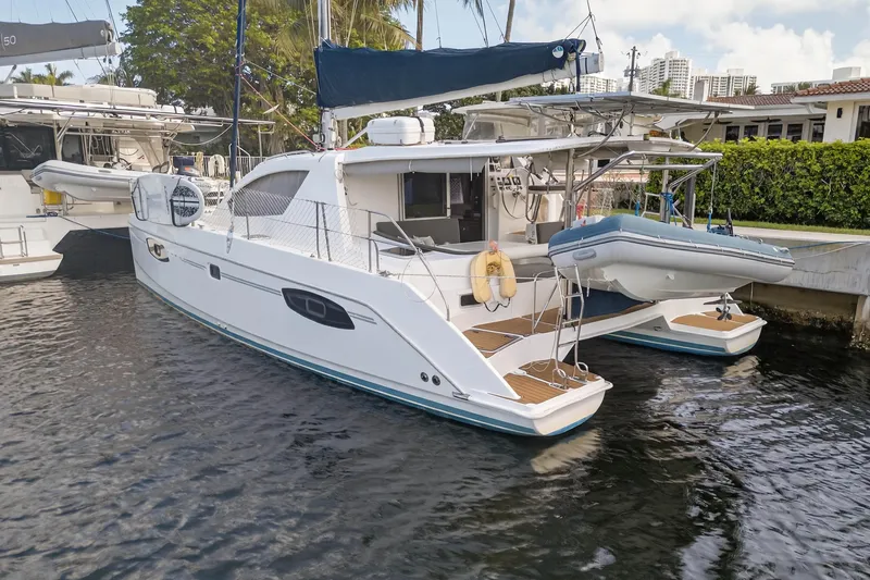 Papillon Yacht Photos Pics 2012 Leopard 39 catamaran docked with dinghy, showcasing sleek design and spacious deck.
