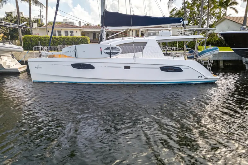Papillon Yacht Photos Pics 2012 Leopard 39 catamaran docked in a marina, surrounded by calm water and palm trees.