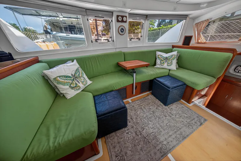 Papillon Yacht Photos Pics Interior of 2012 Leopard 39 yacht with green seating, butterfly pillows, and wooden accents.
