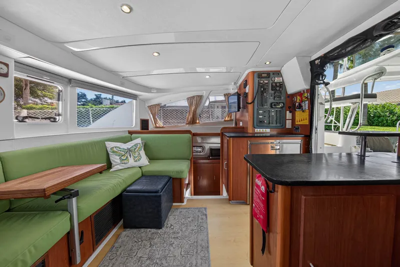 Papillon Yacht Photos Pics Interior of 2012 Leopard 39 yacht with green seating and wooden cabinetry.