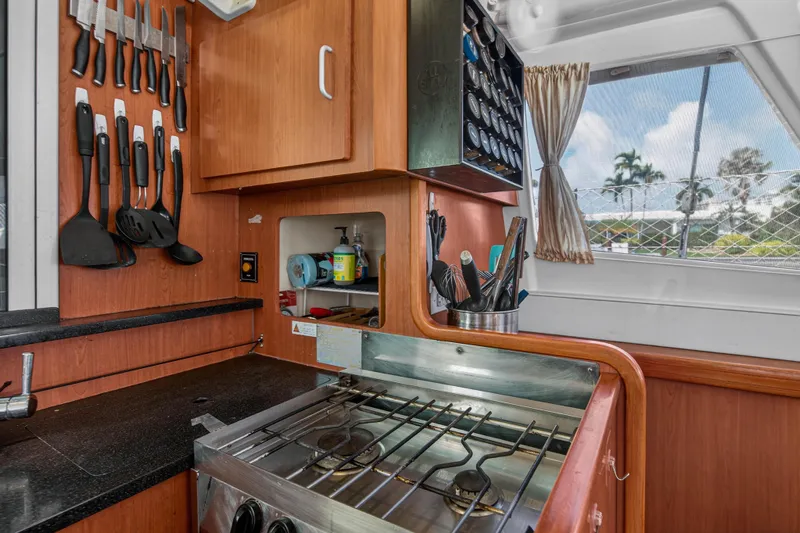Papillon Yacht Photos Pics Compact kitchen in a 2012 Leopard 39 yacht with stove, utensils, and window view.