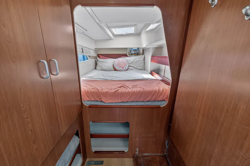 Papillon Yacht Photos Pics Cozy cabin interior of 2012 Leopard 39 yacht with wooden finish and comfortable bedding.