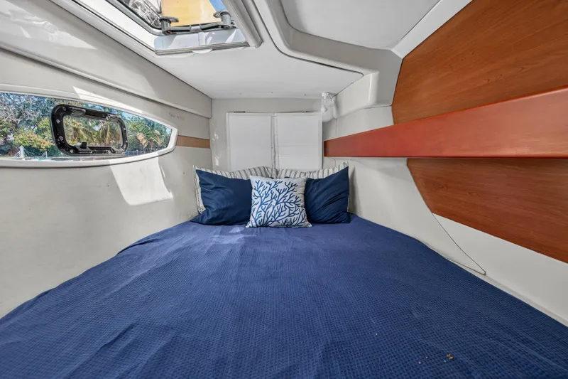 Papillon Yacht Photos Pics Cozy cabin interior of 2012 Leopard 39 yacht with blue bedding and decorative pillows.