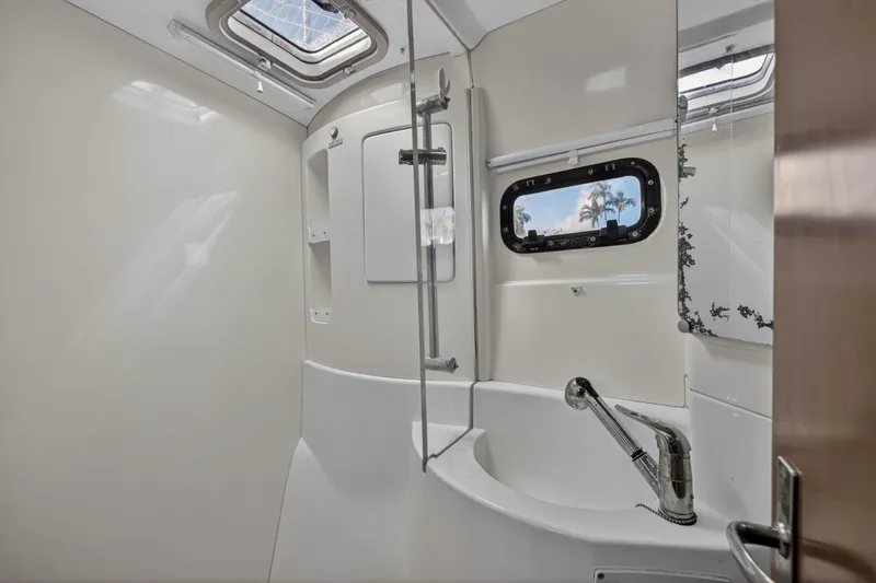 Papillon Yacht Photos Pics Bathroom interior of a 2012 Leopard 39 yacht with modern fixtures and porthole window.
